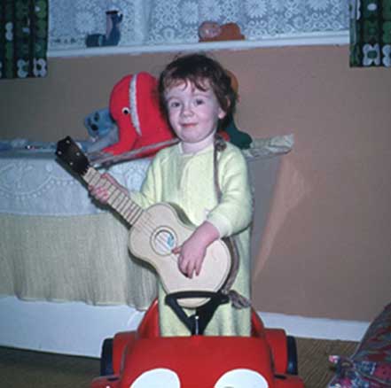 Baby Ginge with guitar.